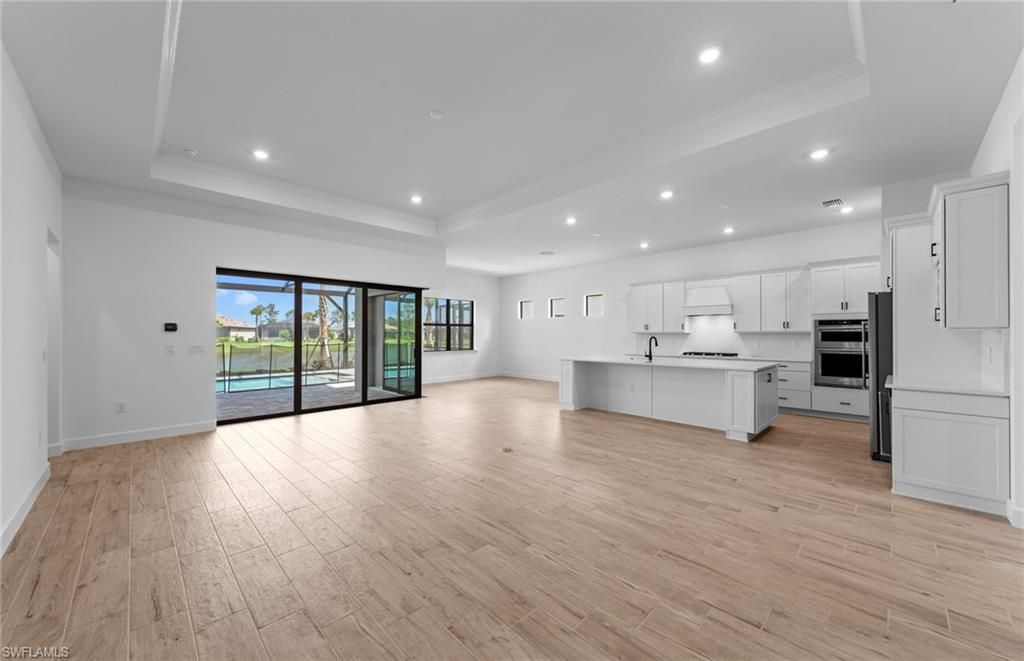 Empty room, Interior, Kitchen, Recessed Lighting, Stainless Steel Appliances, Wood Texture Flooring