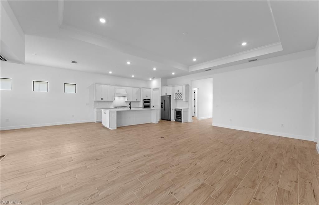 Empty room, Interior, Kitchen, Recessed Lighting, Stainless Steel Appliances, Wood Texture Flooring