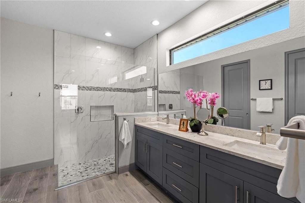 Bathroom, Dual Sink Vanities, Glass Shower, Interior, Marble Walls, Recessed Lighting, Wood Texture Flooring