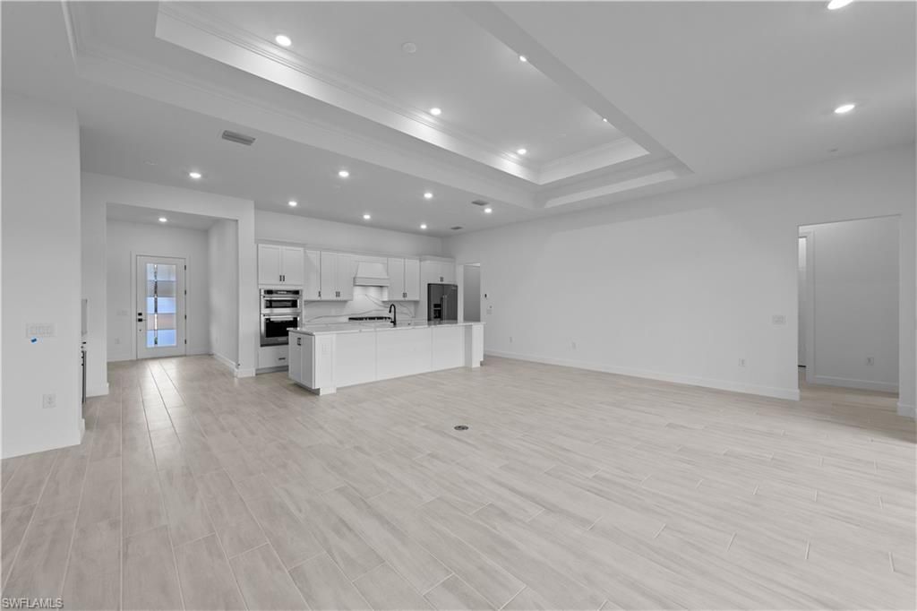Empty room, Interior, Kitchen, Recessed Lighting, Stainless Steel Appliances, Wood Texture Flooring
