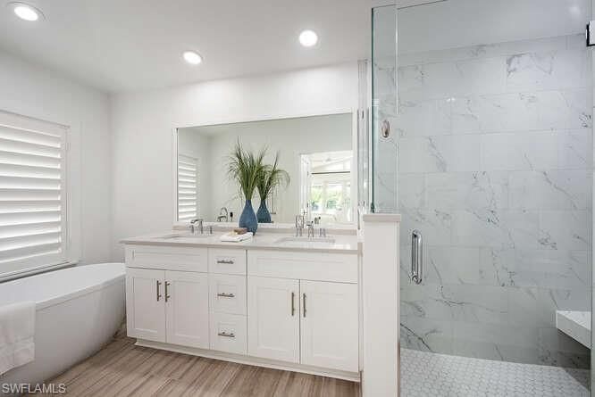 Bathroom, Dual Sink Vanities, Glass Shower, Interior, Marble Walls, Recessed Lighting, Wood Texture Flooring