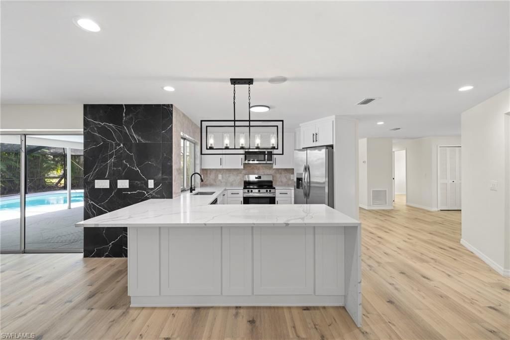 Interior, Kitchen, Marble Walls, Pendant Lights, Recessed Lighting, Stainless Steel Appliances, Wood Texture Flooring