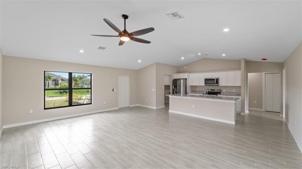 Empty room, Interior, Kitchen, Recessed Lighting, Stainless Steel Appliances, Wood Texture Flooring