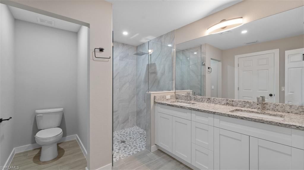 Bathroom, Dual Sink Vanities, Glass Shower, Interior, Marble Walls, Recessed Lighting, Wood Texture Flooring