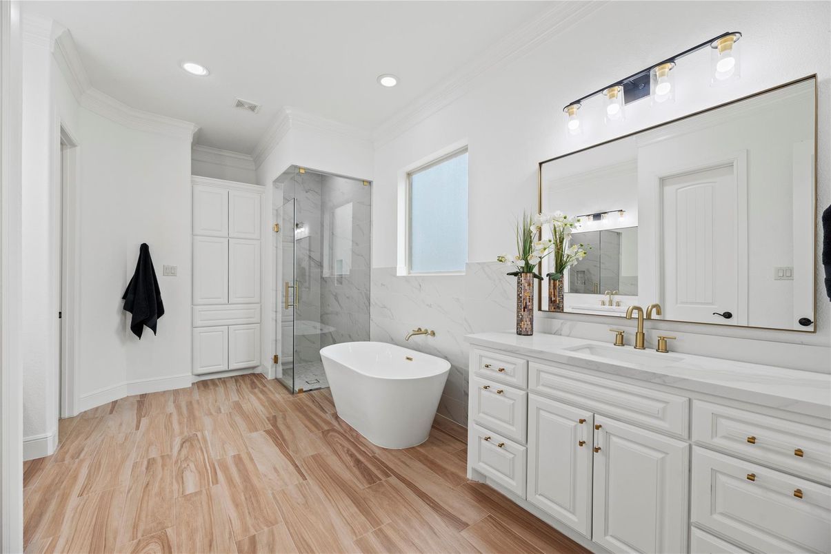 Bathroom, Dual Sink Vanities, Free Standing Baths, Glass Shower, Interior, Marble Walls, Recessed Lighting, Wood Texture Flooring
