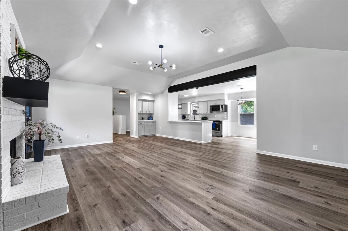 Empty room, Fireplace, Interior, Kitchen, Pendant Lights, Recessed Lighting, Stainless Steel Appliances, Wood Texture Flooring