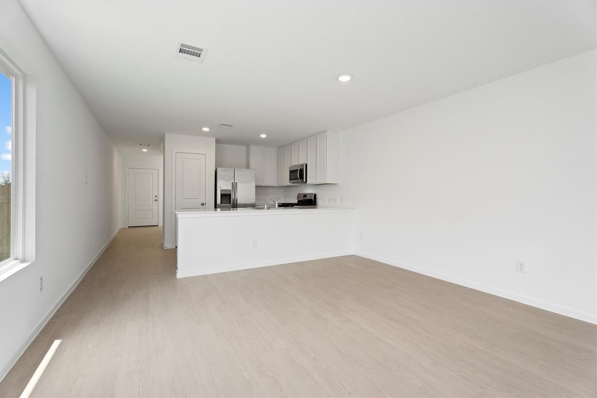 Empty room, Interior, Kitchen, Recessed Lighting, Stainless Steel Appliances, Wood Texture Flooring