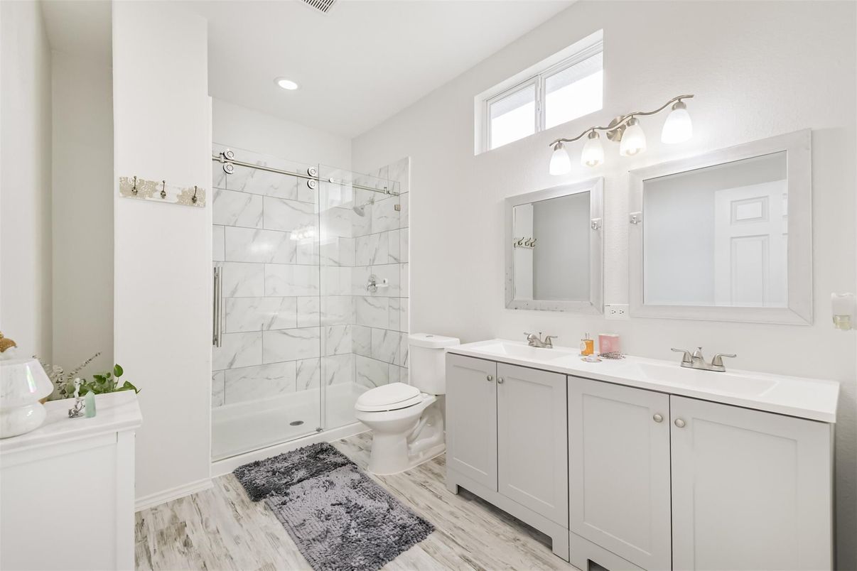 Bathroom, Dual Sink Vanities, Glass Shower, Interior, Marble Walls, Recessed Lighting, Wood Texture Flooring