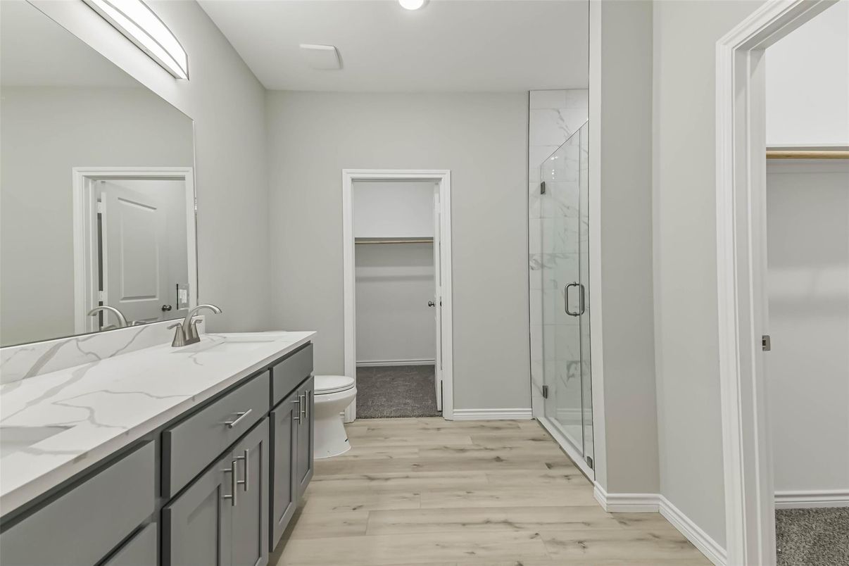 Bathroom, Dual Sink Vanities, Glass Shower, Interior, Marble Walls, Recessed Lighting, Wood Texture Flooring