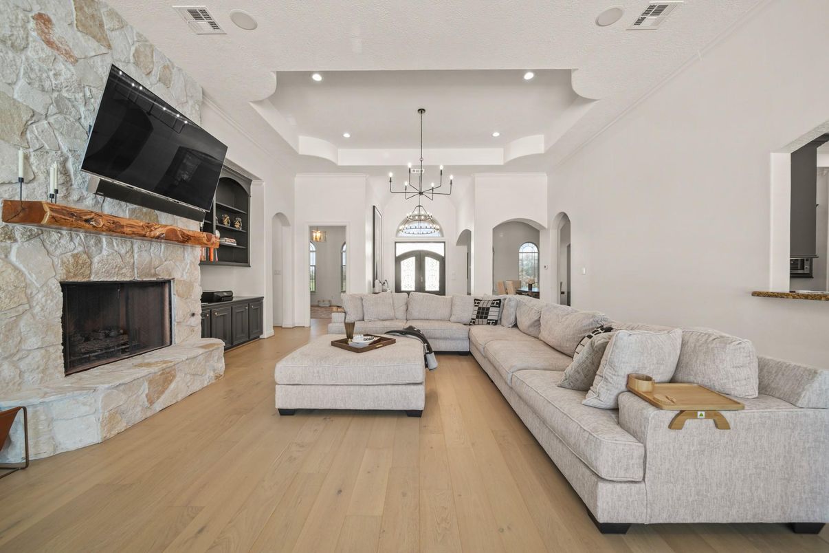 Chandelier, Fireplace, Interior, Living room, Pendant Lights, Recessed Lighting, Stone Walls, Wood Texture Flooring