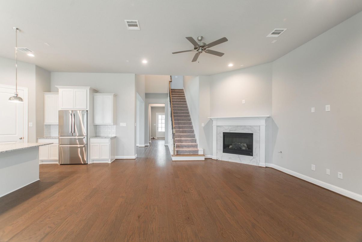 Empty room, Fireplace, Interior, Kitchen, Pendant Lights, Recessed Lighting, Stainless Steel Appliances, Wood Texture Flooring