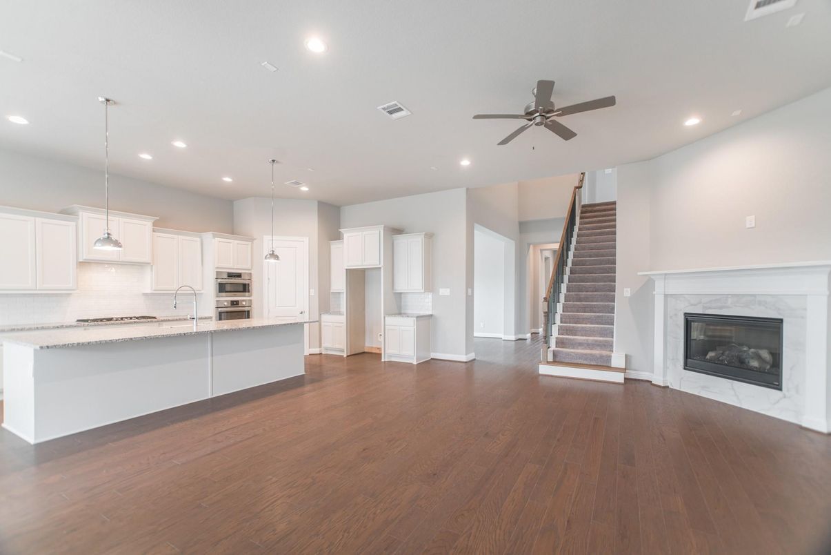 Empty room, Fireplace, Interior, Kitchen, Pendant Lights, Recessed Lighting, Stainless Steel Appliances, Wood Texture Flooring