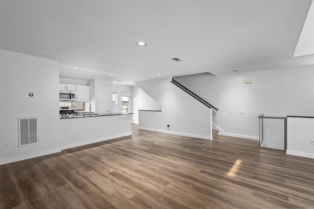 Empty room, Interior, Kitchen, Recessed Lighting, Stainless Steel Appliances, Wood Texture Flooring