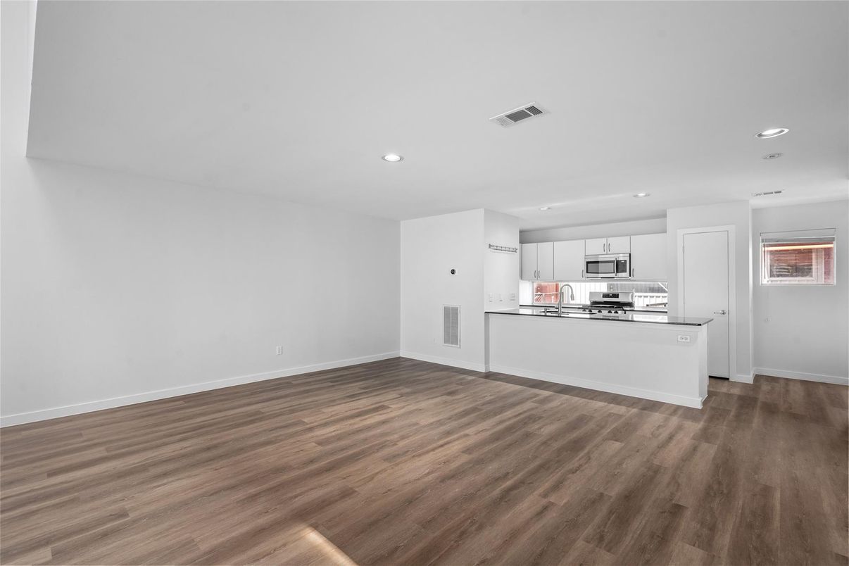 Empty room, Interior, Kitchen, Recessed Lighting, Stainless Steel Appliances, Wood Texture Flooring