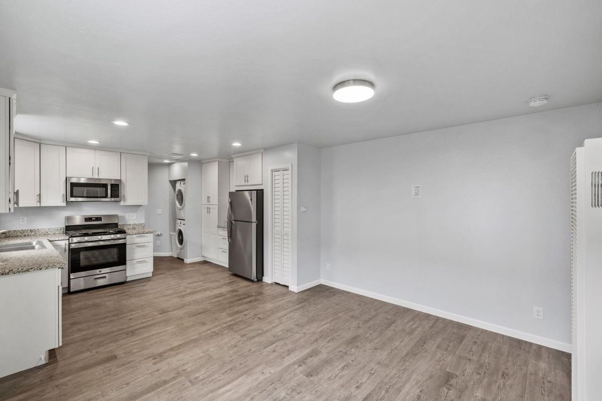 Empty room, Interior, Kitchen, Recessed Lighting, Stainless Steel Appliances, Wood Texture Flooring