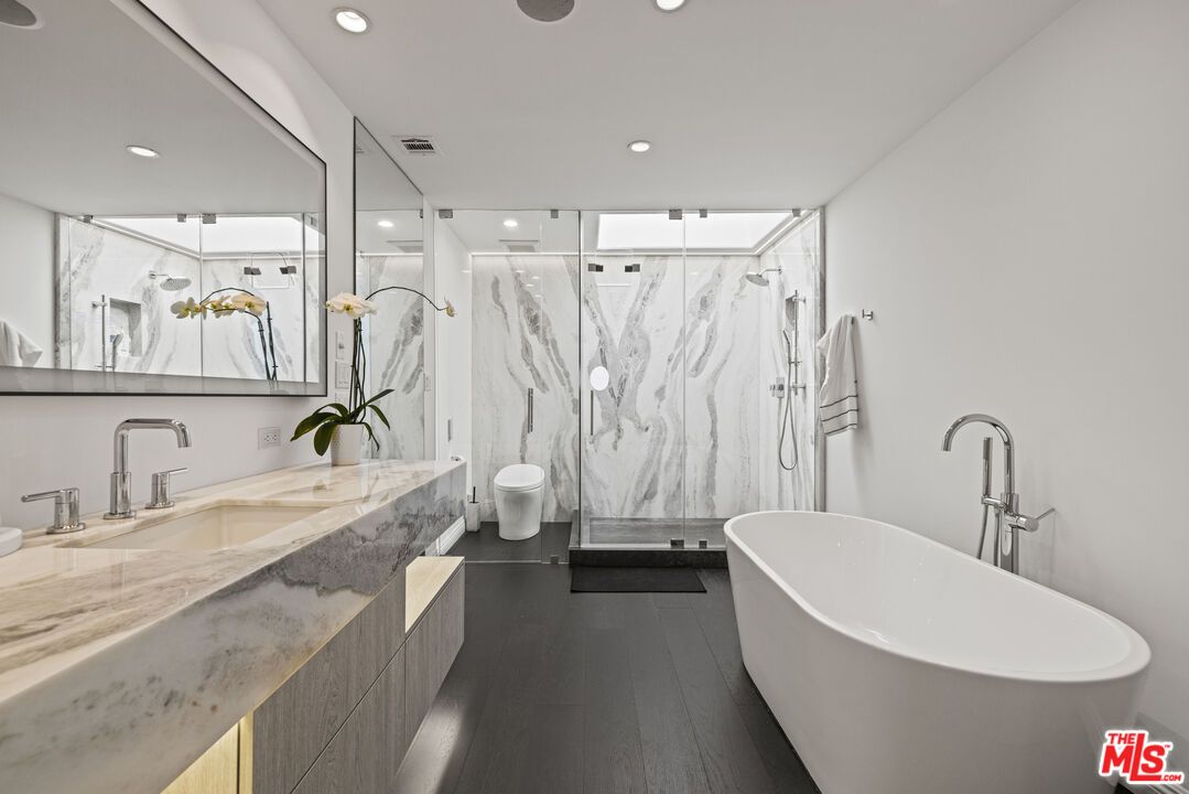 Bathroom, Dual Sink Vanities, Free Standing Baths, Glass Shower, Interior, Marble Walls, Recessed Lighting, Wood Texture Flooring