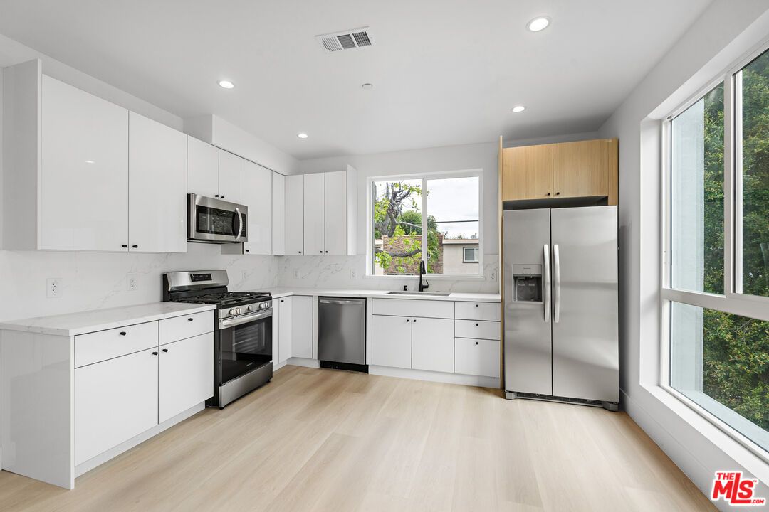 Interior, Kitchen, Marble Walls, Recessed Lighting, Stainless Steel Appliances, Wood Texture Flooring