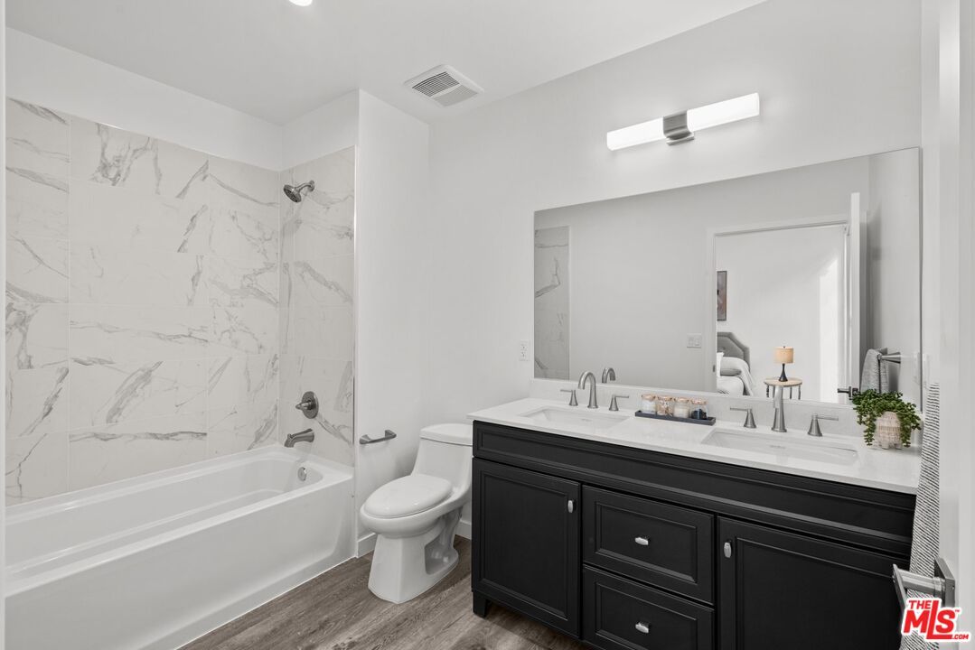 Bathroom, Dual Sink Vanities, Interior, Marble Walls, Recessed Lighting, Wood Texture Flooring