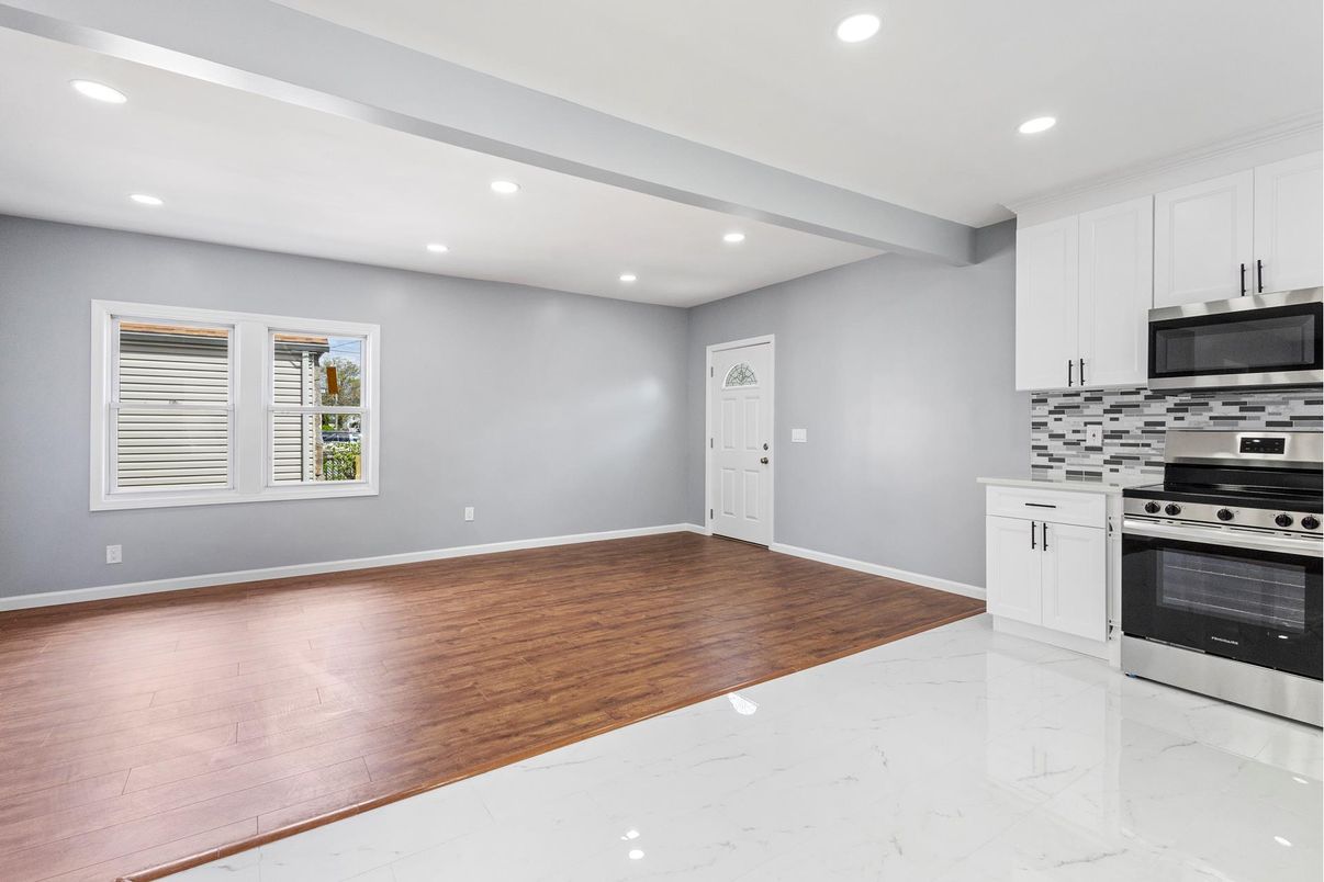 Empty room, Interior, Kitchen, Marble, Recessed Lighting, Stainless Steel Appliances, Wood Texture Flooring