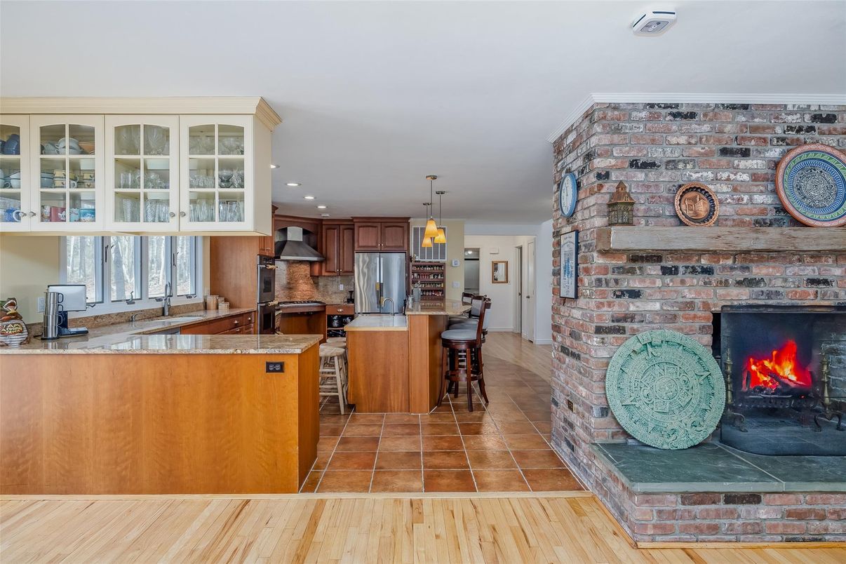 Fireplace, Interior, Kitchen, Pendant Lights, Recessed Lighting, Stainless Steel Appliances, Stone Walls, Wood Texture Flooring