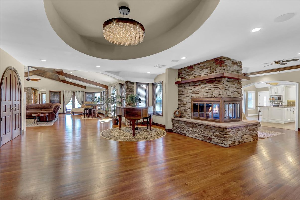 Chandelier, Fireplace, Interior, Living room, Piano, Recessed Lighting, Stone Walls, Wooden Beams, Wood Texture Flooring