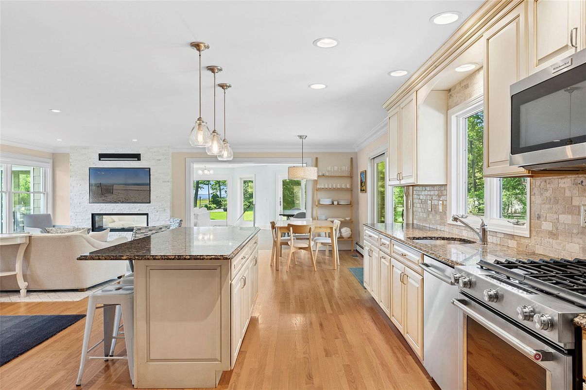 Chandelier, Dining room, Interior, Kitchen, Living room, Pendant Lights, Recessed Lighting, Stainless Steel Appliances, Stone Walls, Wood Texture Flooring