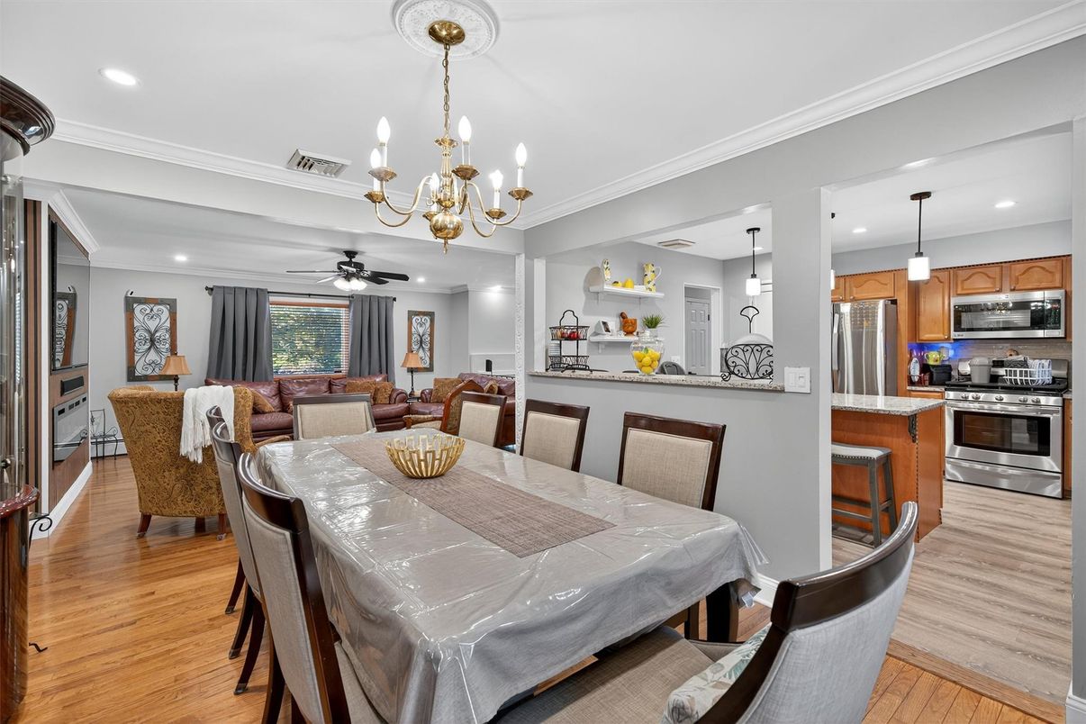 Chandelier, Dining room, Interior, Kitchen, Living room, Pendant Lights, Recessed Lighting, Stainless Steel Appliances, Wood Texture Flooring