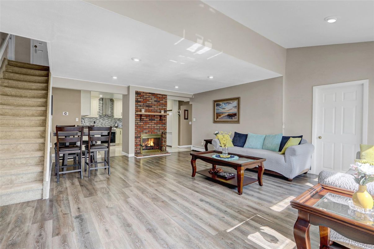 Dining room, Fireplace, Interior, Living room, Recessed Lighting, Stone Walls, Wood Texture Flooring