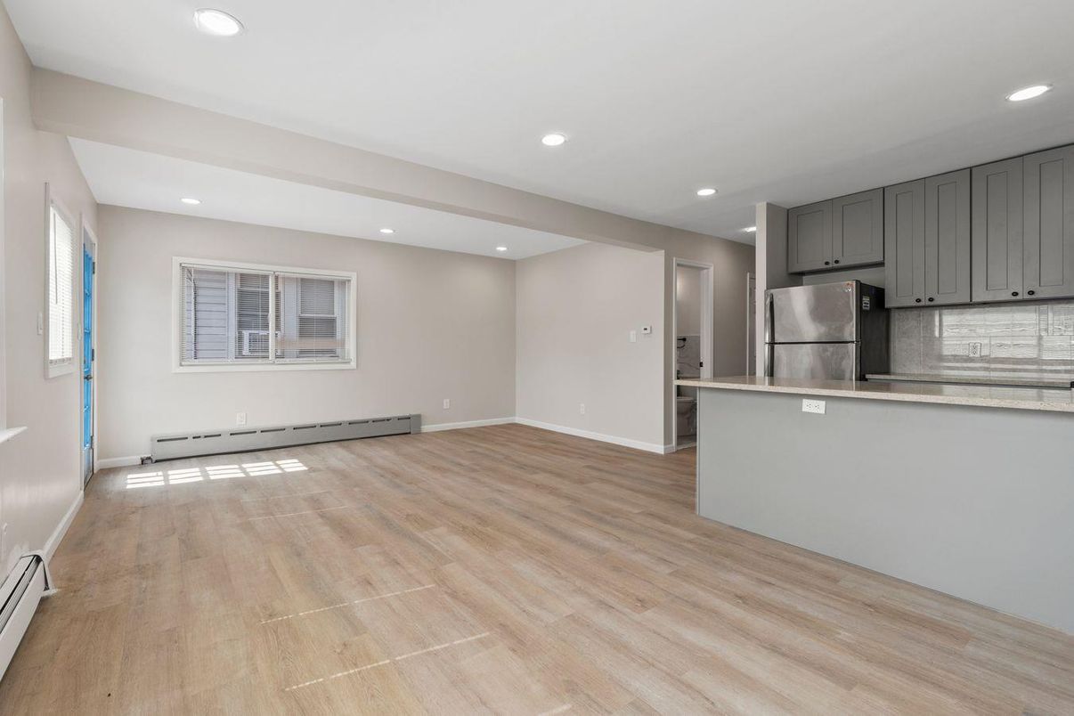 Empty room, Interior, Kitchen, Recessed Lighting, Stainless Steel Appliances, Wood Texture Flooring