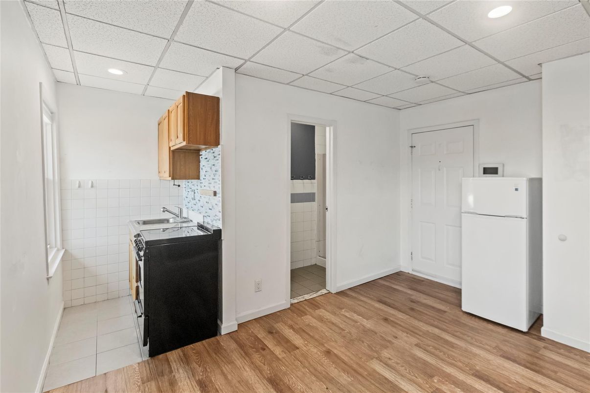 Interior, Kitchen, Recessed Lighting, Tile Countertops, Washer, Wood Texture Flooring