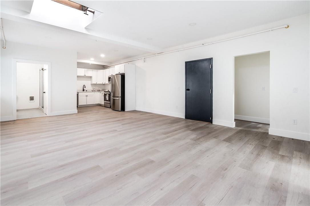 Empty room, Interior, Kitchen, Recessed Lighting, Stainless Steel Appliances, Wood Texture Flooring