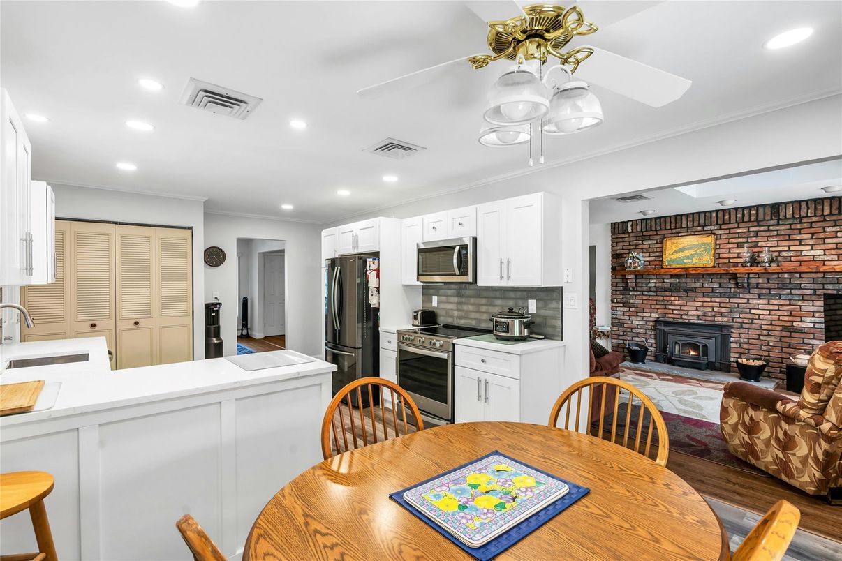 Dining room, Fireplace, Interior, Kitchen, Recessed Lighting, Stainless Steel Appliances, Stone Walls, Wood Texture Flooring
