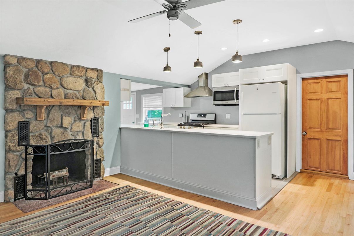 Fireplace, Interior, Kitchen, Pendant Lights, Recessed Lighting, Stainless Steel Appliances, Stone Walls, Wood Texture Flooring