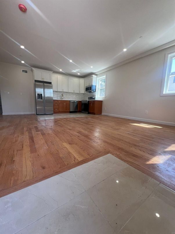 Empty room, Interior, Kitchen, Recessed Lighting, Stainless Steel Appliances, Wood Texture Flooring
