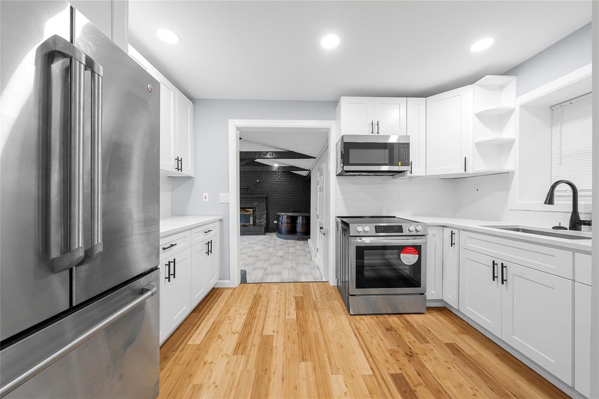 Fireplace, Interior, Kitchen, Recessed Lighting, Stainless Steel Appliances, Wood Texture Flooring