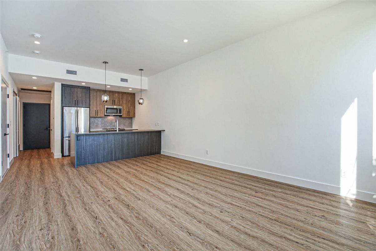 Empty room, Interior, Kitchen, Pendant Lights, Recessed Lighting, Stainless Steel Appliances, Wood Texture Flooring