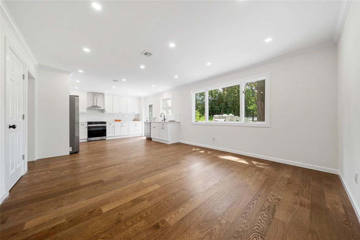 Empty room, Interior, Kitchen, Recessed Lighting, Stainless Steel Appliances, Wood Texture Flooring
