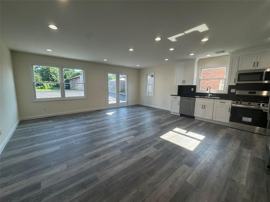 Empty room, Interior, Kitchen, Recessed Lighting, Stainless Steel Appliances, Wood Texture Flooring