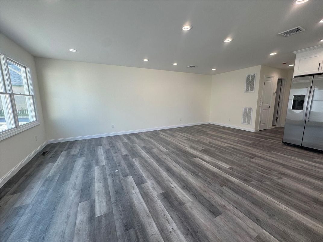 Empty room, Interior, Kitchen, Recessed Lighting, Stainless Steel Appliances, Wood Texture Flooring