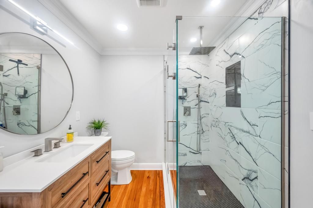 Bathroom, Dual Sink Vanities, Glass Shower, Interior, Marble Walls, Recessed Lighting, Wood Texture Flooring