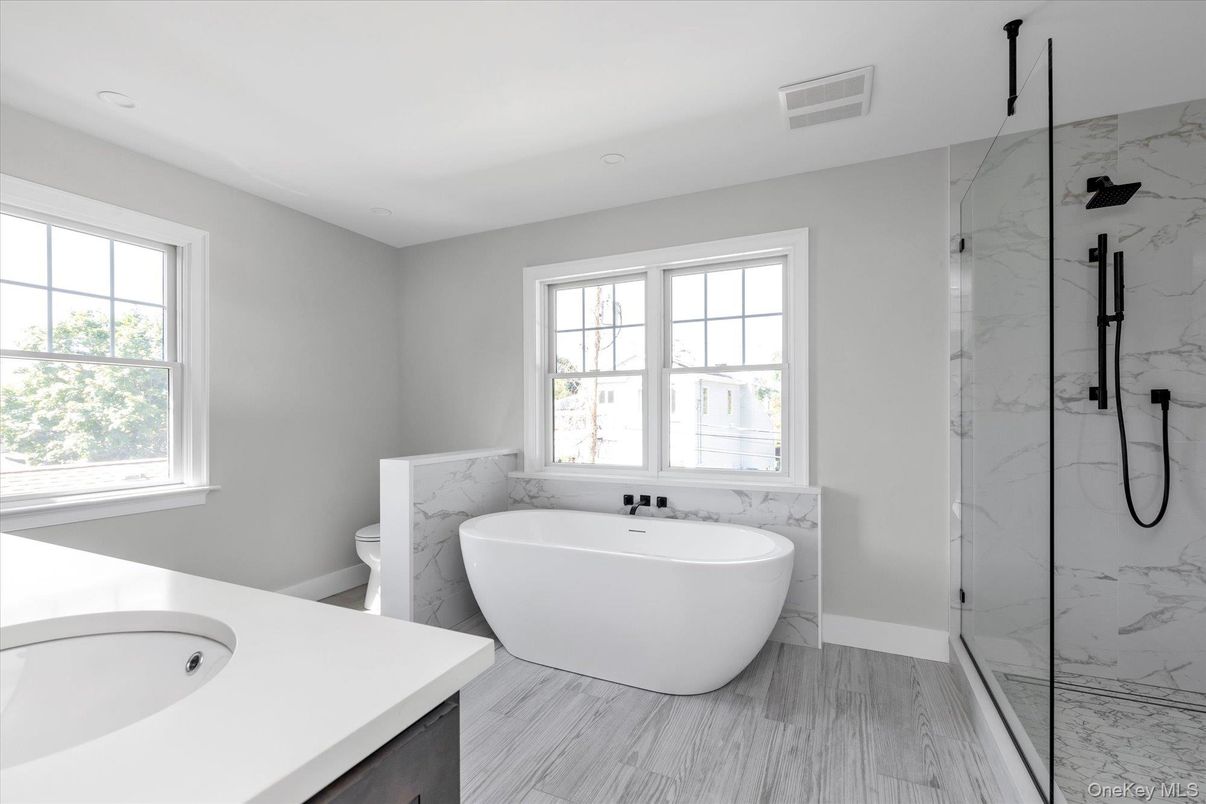 Bathroom, Free Standing Baths, Glass Shower, Interior, Marble Walls, Recessed Lighting, Wood Texture Flooring