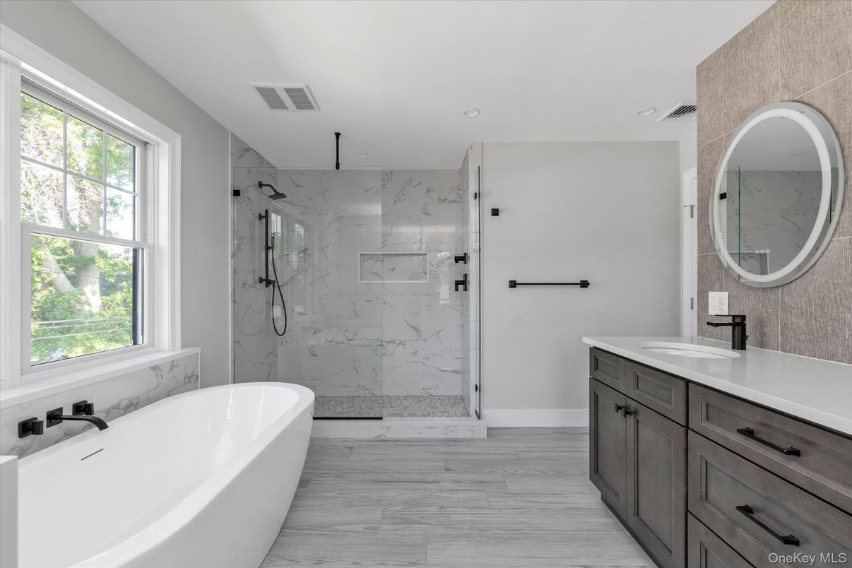 Bathroom, Dual Sink Vanities, Free Standing Baths, Glass Shower, Interior, Marble Walls, Recessed Lighting, Wood Texture Flooring