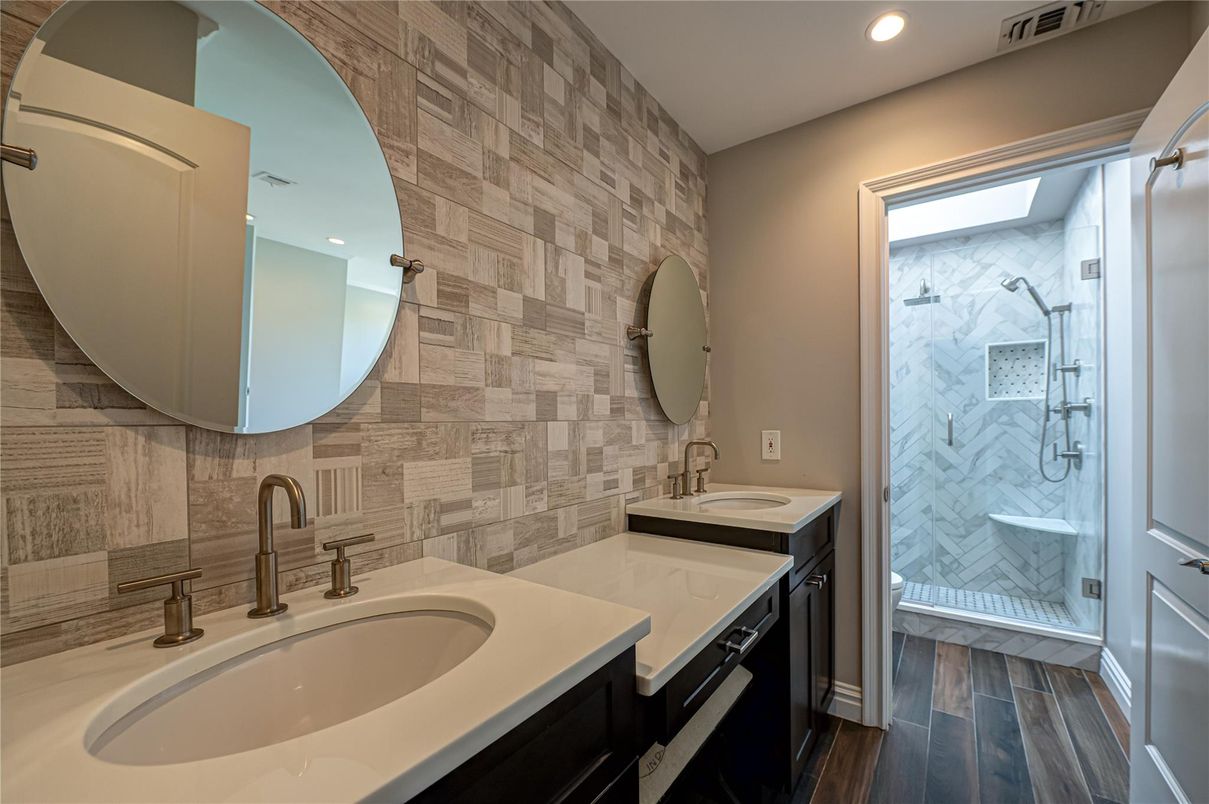 Bathroom, Dual Sink Vanities, Glass Shower, Interior, Marble Walls, Recessed Lighting, Wood Texture Flooring