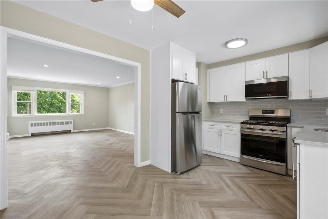 Empty room, Interior, Kitchen, Recessed Lighting, Stainless Steel Appliances, Wood Texture Flooring
