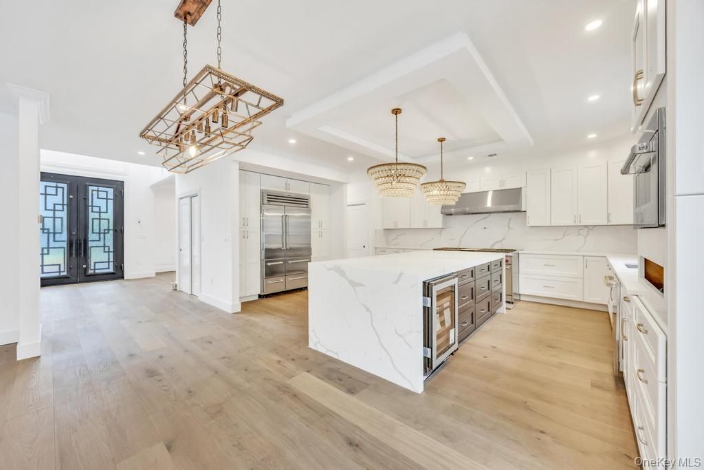 Chandelier, Interior, Kitchen, Marble Walls, Pendant Lights, Recessed Lighting, Stainless Steel Appliances, Wood Texture Flooring