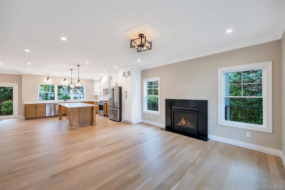 Empty room, Fireplace, Interior, Kitchen, Pendant Lights, Recessed Lighting, Stainless Steel Appliances, Wood Texture Flooring