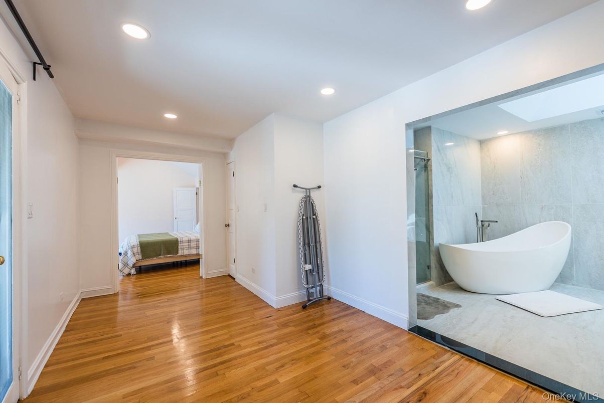 Bathroom, Free Standing Baths, Glass Shower, Interior, Marble Walls, Recessed Lighting, Wood Texture Flooring
