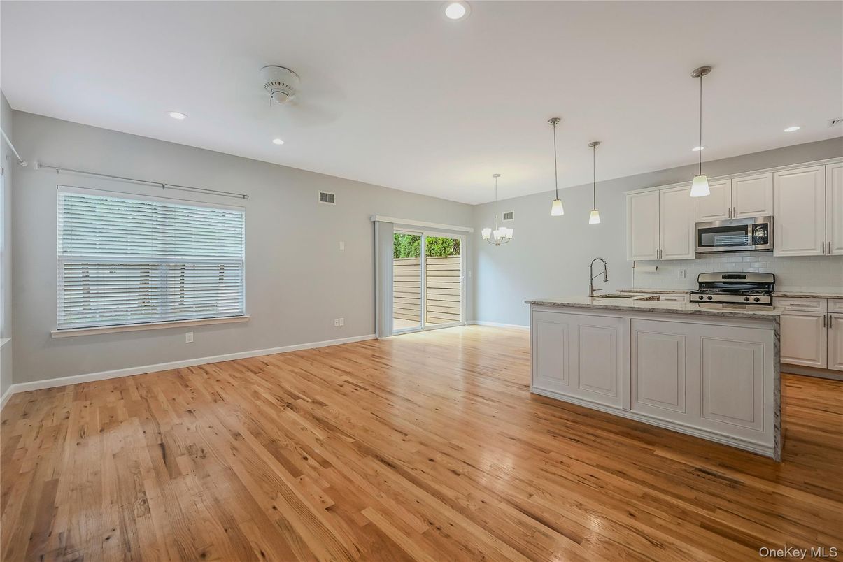 Empty room, Interior, Kitchen, Pendant Lights, Recessed Lighting, Stainless Steel Appliances, Wood Texture Flooring