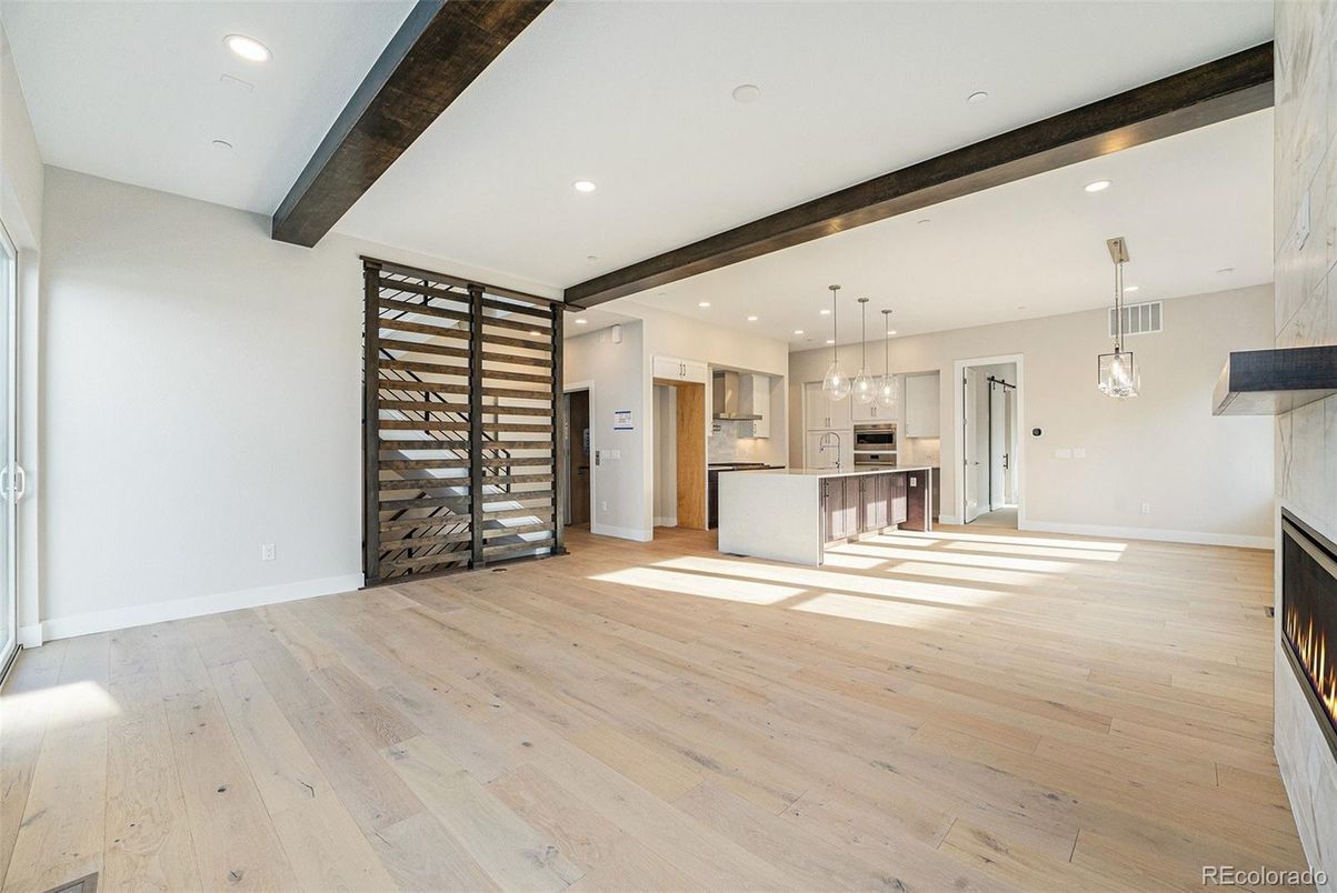 Empty room, Fireplace, Interior, Kitchen, Pendant Lights, Recessed Lighting, Stainless Steel Appliances, Wooden Beams, Wood Texture Flooring