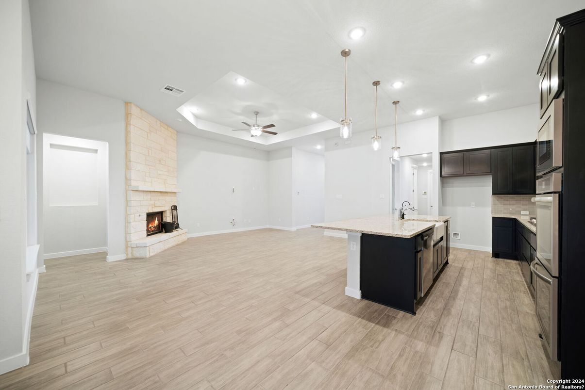 Empty room, Fireplace, Interior, Kitchen, Pendant Lights, Recessed Lighting, Stone Walls, Wood Texture Flooring